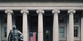 Statue and American flag outside Treasury Department building.