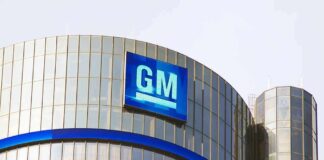 Glass building with large GM logo on top.