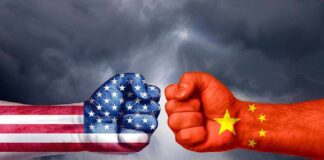 Fists painted like USA and China flags facing off.