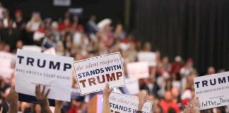 Crowd holding signs supporting Trump at a rally.