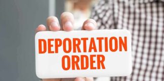 Hand holding sign with "Deportation Order" text.