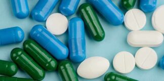 Blue, green, and white pills scattered on surface.