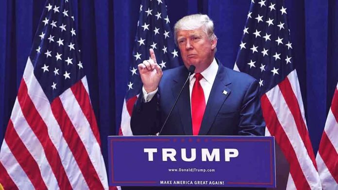 1456399979 featured image Man speaking at podium with American flags behind.