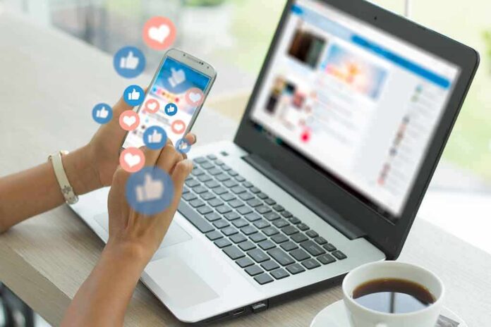 1573945981 featured image Person using phone with social media reactions floating