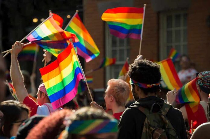 1099936808 featured image People holding rainbow flags at an outdoor gathering