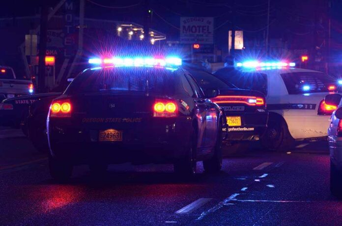 Police cars with flashing lights at nighttime.