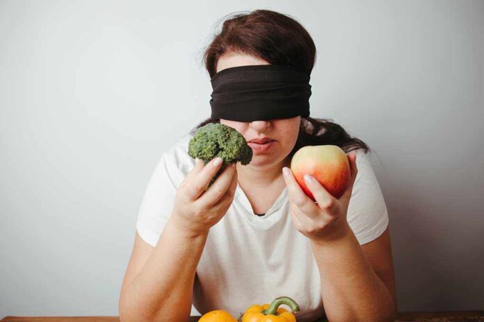 1870054642 featured image Blindfolded person holding broccoli and an apple.