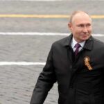 Man in black coat on paved street.
