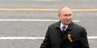 Man in black coat on paved street.