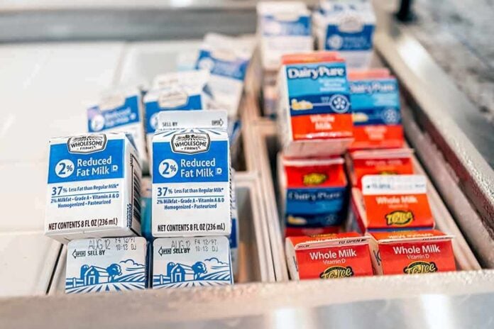 2128690232 featured image Milk cartons in a refrigerated display case.
