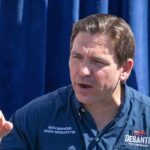 Florida Political Drama Unfolds: DeSantis and Fine’s Post-Election Tensions Man in "Desantis for President" shirt speaking.