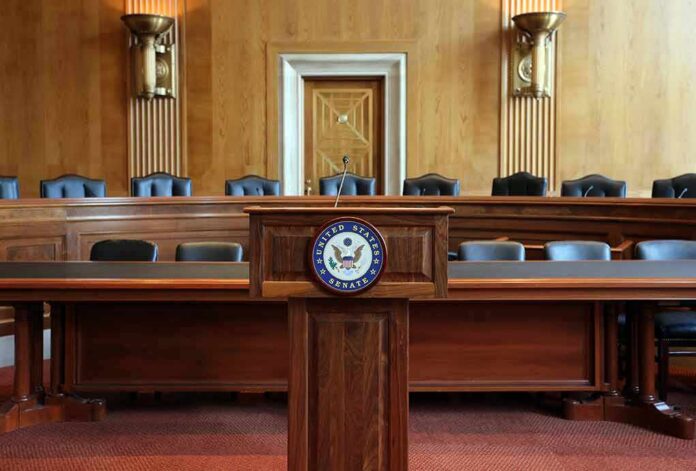 686344315 featured image Empty U.S. Senate hearing room with wooden furniture.