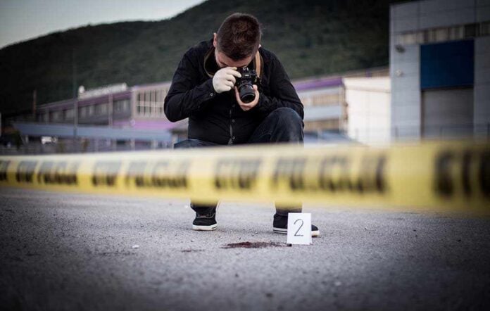 702059647 featured image Photographer documenting crime scene behind caution tape