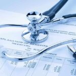 Stethoscope and pen on medical benefits document