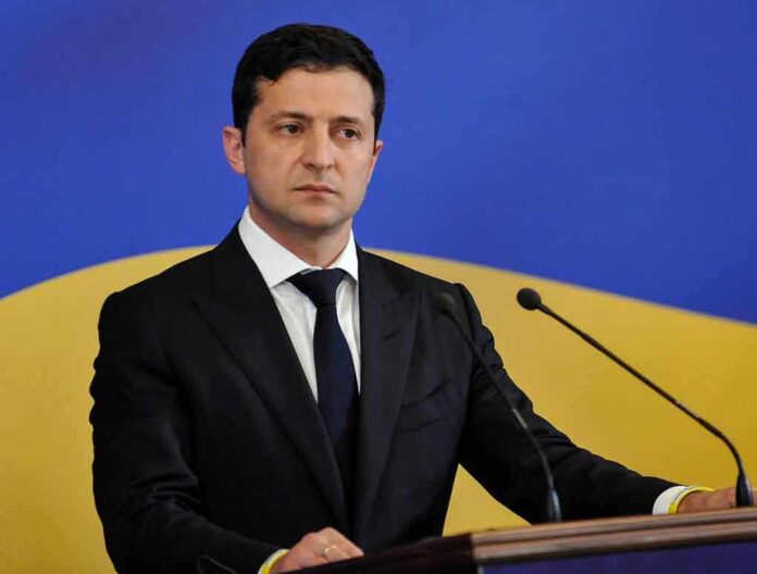 1448861675 featured image Man in suit speaking at podium with microphones
