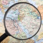 Magnifying glass over Middle East map highlighting Israel and Egypt