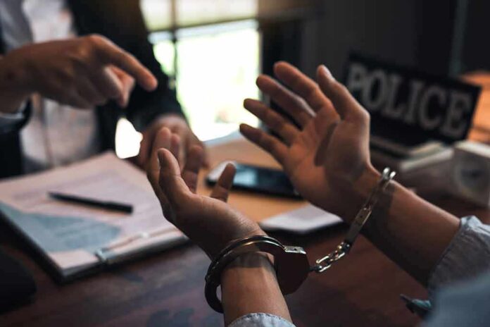 1669066165 featured image Person in handcuffs being interrogated by officer