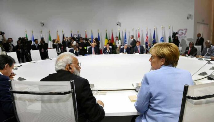 1970862773 featured image People seated around a large round table flags behind