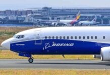 Boeing on airport runway with other planes