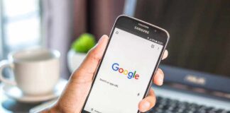 Hand holding smartphone with Google search page