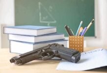 Gun on desk with school supplies and books