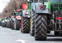 Tractors lined up on a city street.