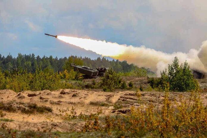 1302196150 Military tank firing a missile in forest area