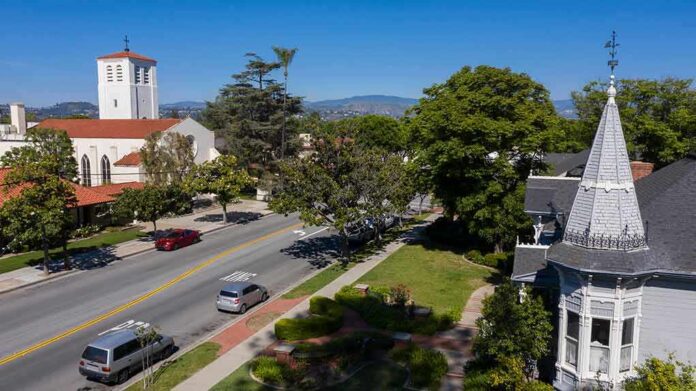 Street with church parked cars and trees