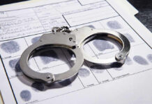 Handcuffs on fingerprint form with fingerprints visible