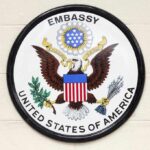 Seal of the United States Embassy featuring an eagle and the American flag