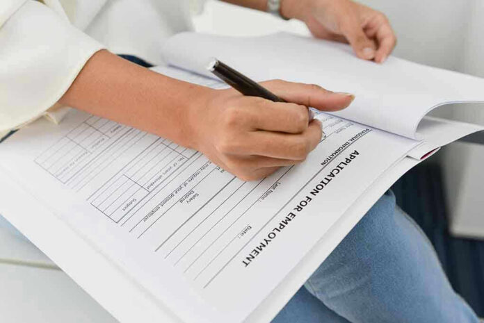 Person filling out job application form.