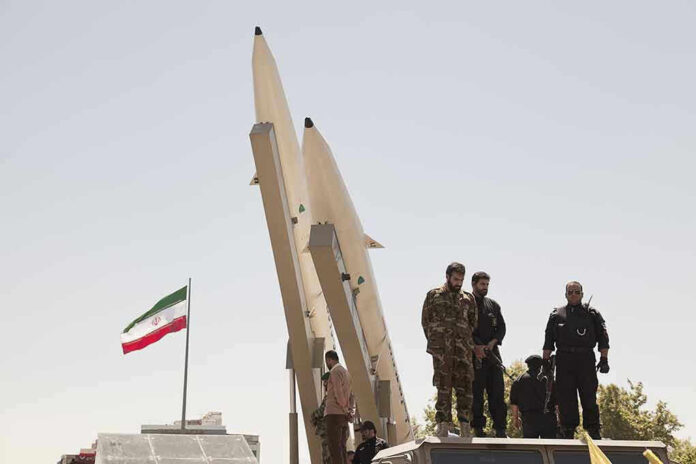 Military personnel beside missiles and Iranian flag