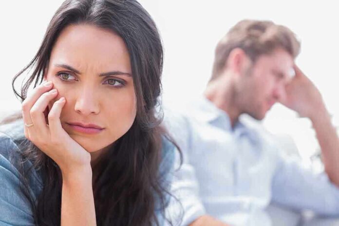 A woman looking concerned while a man appears distressed in the background