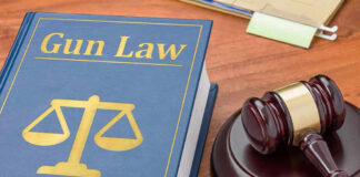 Gun Law book and gavel on wooden desk.