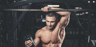 Muscular man in gym holding a shaker bottle