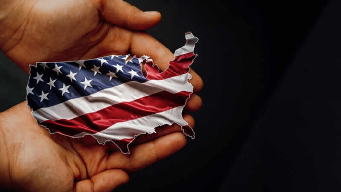 article_shutterstock_2511708017.jpg A hand holding a map of the United States adorned with the American flag