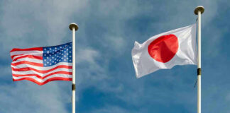 USA and Japan flags flying on flagpoles.