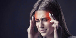 Woman holding head, experiencing intense headache or migraine.