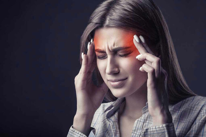 Woman holding head, experiencing intense headache or migraine.