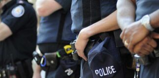 Group of police officers in uniform standing together with a police cap visible