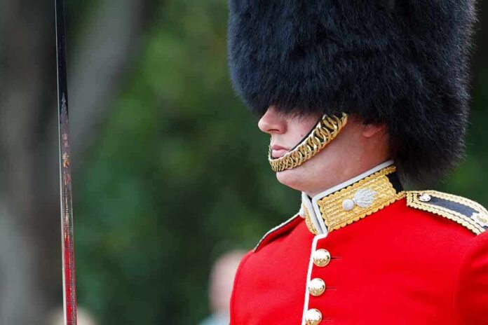 British soldier in ceremonial uniform with a black fur hat standing guard