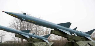 Three missile launchers with missiles positioned on a military display