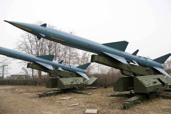 Three missile launchers with missiles positioned on a military display