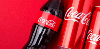 Coca-Cola bottles and cans on red background.
