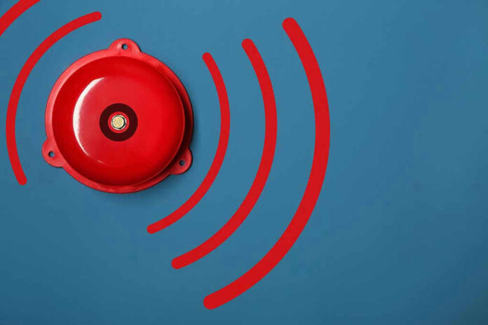 Red alarm bell on a blue background.