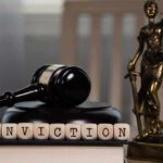A gavel and the word CONVICTION spelled with wooden blocks