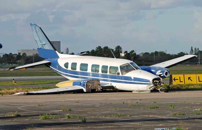 Damaged blue and white small airplane on an airport runway