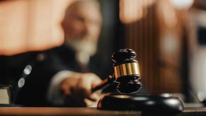 Judge using gavel in a courtroom setting.