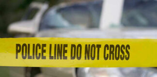 Yellow police tape in front of a car.