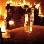 OVERCROWDED Mall Fire — Bodies Keep Emerging A firefighter battling a large house fire at night